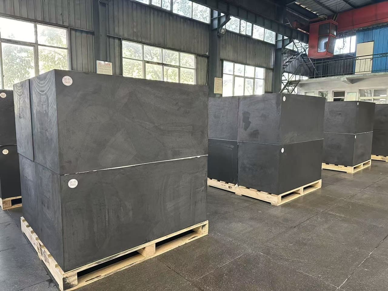 Visual inspection of a carbon block A stack of industrial carbon blocks of varying shades and textures