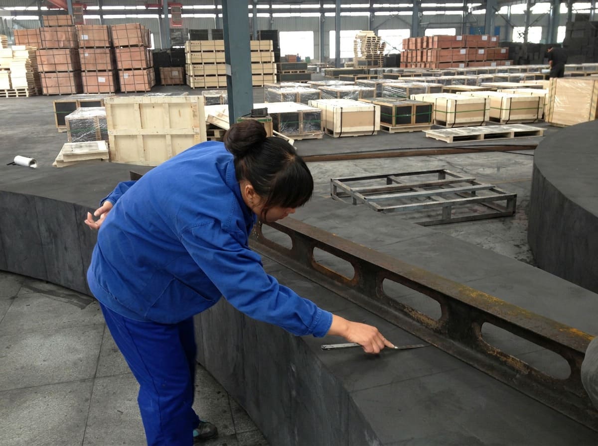Technical Specifications for Graphite Refractories A technician inspecting a carbon block with calipers, symbolizing the importance of technical specifications for graphite in refractories